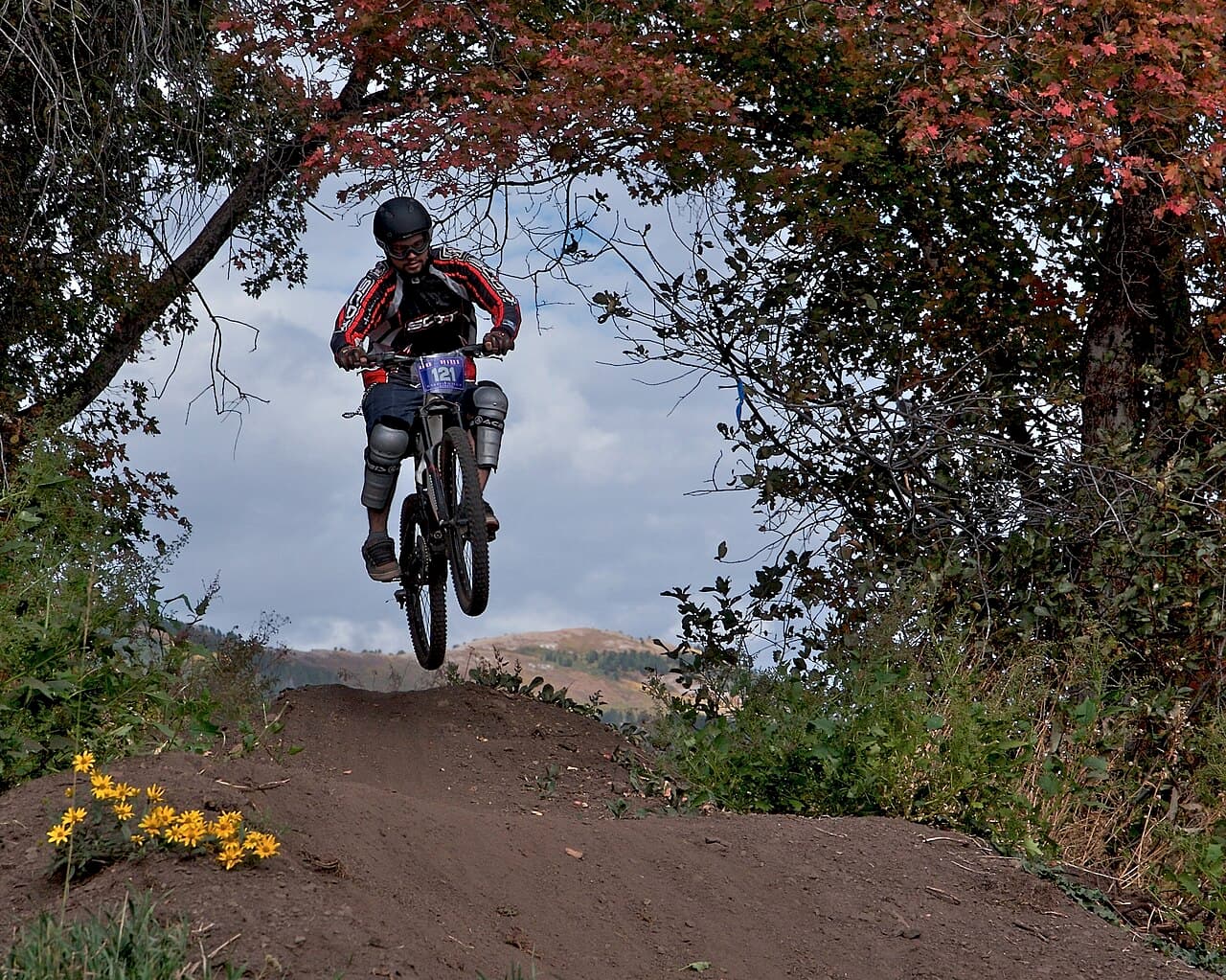 Illustrative photo of a mountain biker jumping over a trail feature; not a photo of this venue.